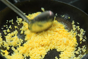 大火加熱炒鍋，再入油，燒到四至五成熱時倒入雞蛋液，在未凝結(jié)之前，加米飯煸炒，不停翻炒并用鍋鏟將成塊的米飯碾開、撥散。