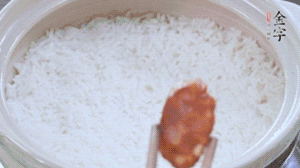 煮開后轉(zhuǎn)小火，當(dāng)米飯出現(xiàn)小孔時(shí)，鋪上金字麻辣香腸。