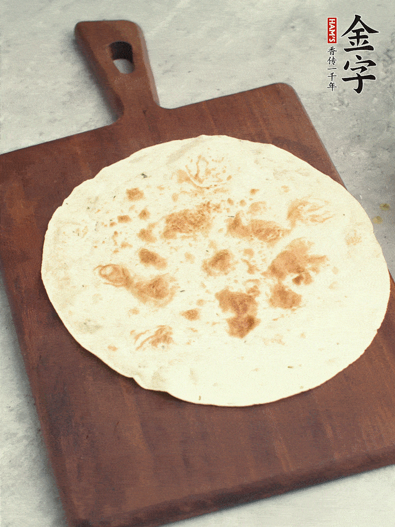 食材依次鋪在卷餅皮上，卷起來。