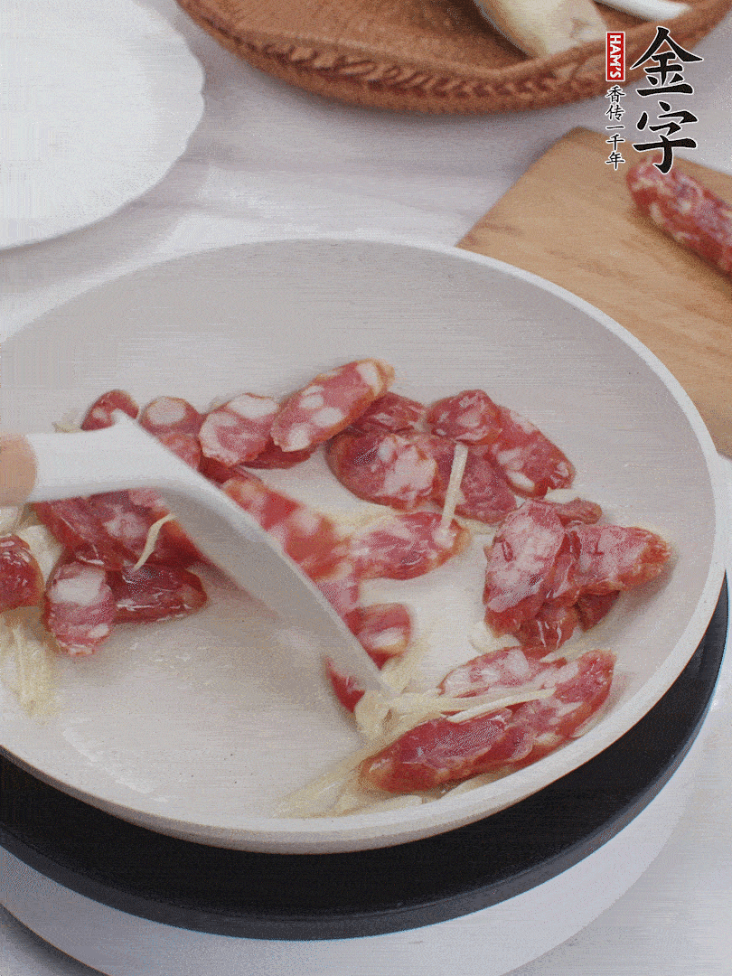 油溫3成熱時，下姜絲、蒜片、香腸炒出油脂。