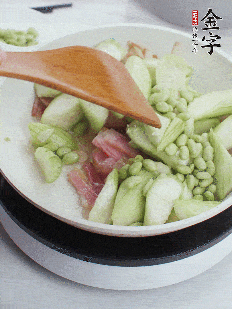 依次下絲瓜、青豆翻炒，炒至絲瓜打蔫縮小。