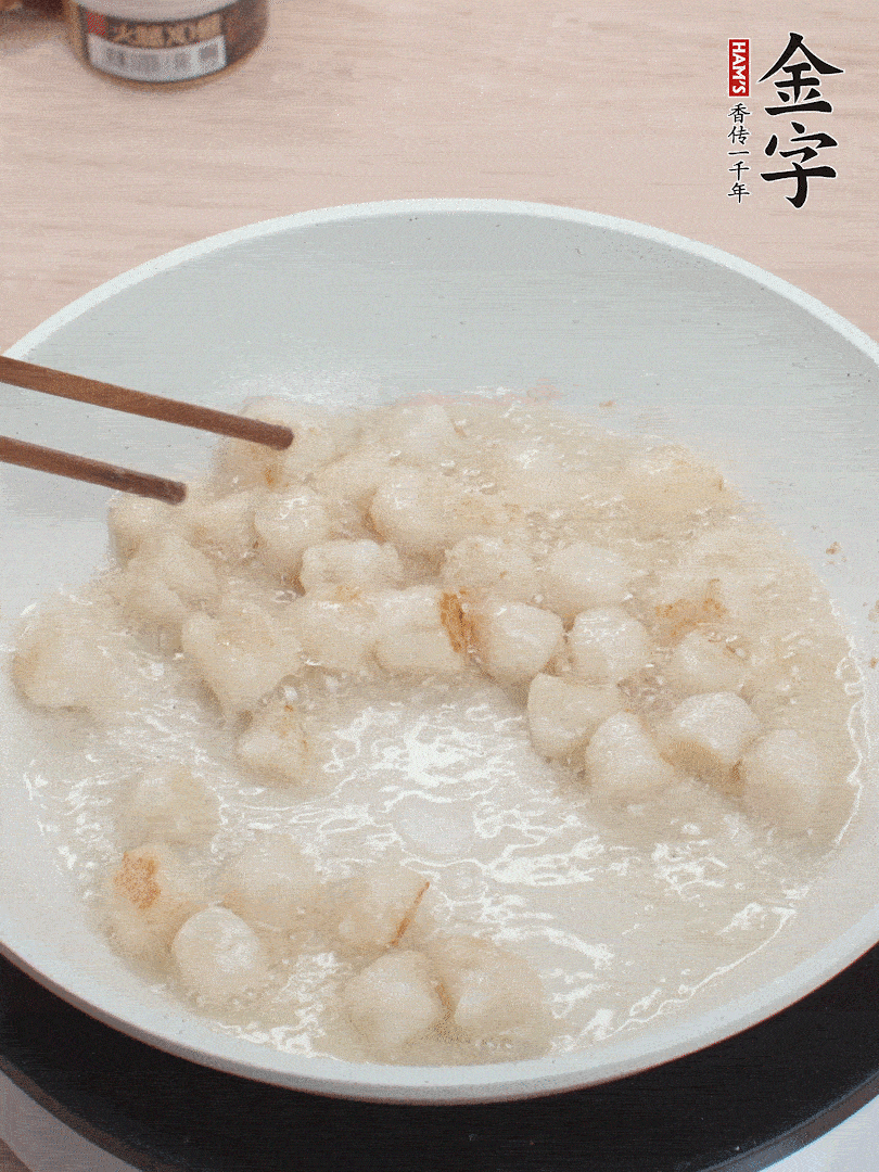 油溫4成熱，鮮貝蘸干淀粉下鍋煎，一面微黃后翻面。