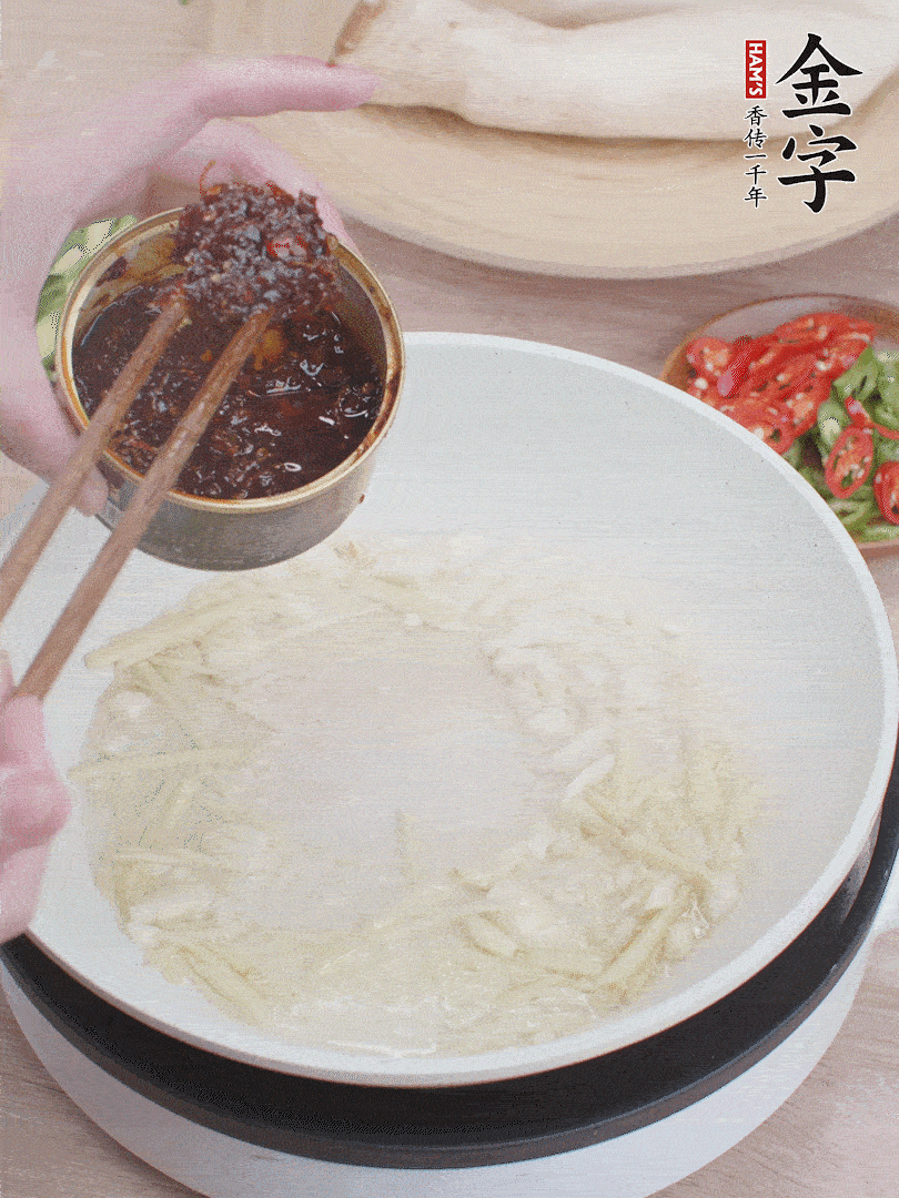 起鍋熱油，姜蒜、金字火腿干貝醬煸香。