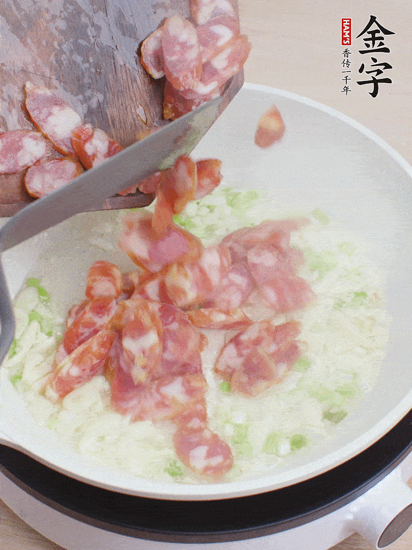 油5成熱，蒜末、蔥白爆香，下香腸炒出香味。