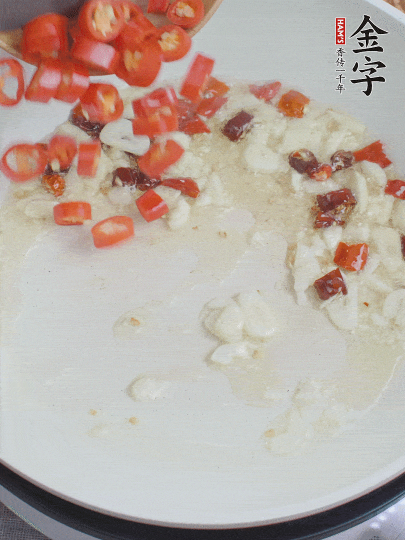 油6成熱，下蒜末、干紅辣椒煸炒，出香味后再放美人椒、香腸。