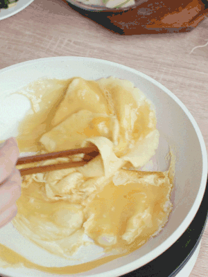 油6成熱時(shí)，下雞蛋液，邊緣凝固時(shí)翻拌成塊狀。