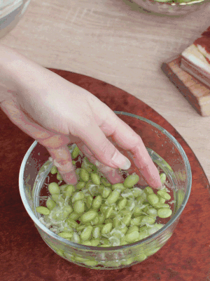 青豆剝殼，搓去外衣。