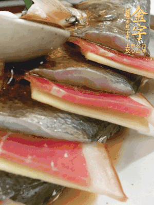 魚肚中塞蔥結(jié)、火腿片，魚身上碼放姜片、火腿片，倒入混合的料汁。