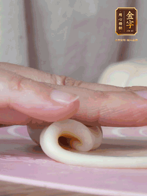 做面劑 油皮按扁，中間包入一個(gè)油酥，邊緣收緊捏死。包好的面劑按扁，用搟面杖搟壓成橢圓形。從底部向上卷成筒狀，用保鮮膜蓋好松弛15分鐘，再把筒狀縱向搟壓成長(zhǎng)條狀。再卷一次，松弛20分鐘