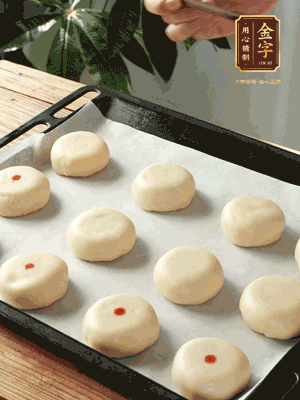 收口向下放在案板上，輕輕將月餅坯按扁，用筷子點(diǎn)紅點(diǎn)做裝飾