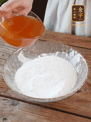 轉(zhuǎn)化糖漿、枧水、花生油攪拌均勻，加入面粉混合，醒發(fā)2小時(shí)。捏成23g一個(gè)的小球