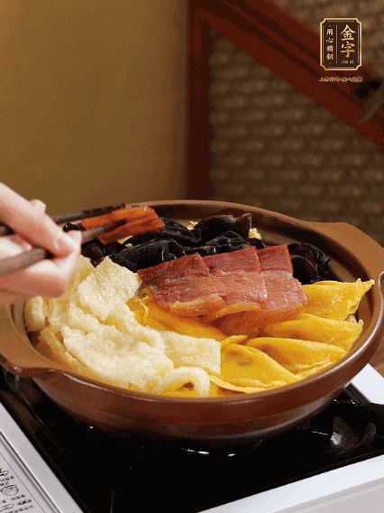 砂鍋底部鋪上娃娃菜，依次擺上肉皮、蛋餃、黑木耳、火腿